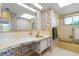 Bathroom featuring floral wallpaper, bright lights, and a shower/bathtub combo at 2501 Rio Largo Ct, Punta Gorda, FL 33950