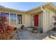 The front of the house features a red door, pretty bushes, and a walkway at 2501 Rio Largo Ct, Punta Gorda, FL 33950