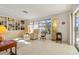 Bright living room with large windows, two recliners, built in shelves, and Terrazzo flooring at 2501 Rio Largo Ct, Punta Gorda, FL 33950