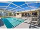 A refreshing screened-in pool is surrounded by ample patio space, perfect for outdoor relaxation and entertaining at 2501 Rio Largo Ct, Punta Gorda, FL 33950