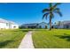 Landscaped backyard with a walkway to the home at 5117 Collingswood Blvd, Port Charlotte, FL 33948