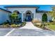 Front entrance with arched entryway and blue double doors at 5117 Collingswood Blvd, Port Charlotte, FL 33948