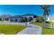 Modern home with metal roof and stone accents, featuring a long driveway at 5117 Collingswood Blvd, Port Charlotte, FL 33948