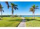 Scenic waterfront path with lush landscaping and palm trees at 5117 Collingswood Blvd, Port Charlotte, FL 33948