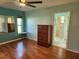 Main bedroom with laminate flooring, a window, and an ensuite bathroom featuring a tiled shower at 12070 Surrey Ave, Port Charlotte, FL 33981