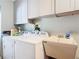 Bright laundry room with built-in cabinets and utility sink at 14454 Nw Chamberlain Blvd, Port Charlotte, FL 33953