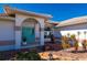 Front entry with arched entryway, teal door, and stone landscaping at 831 Via Tunis, Punta Gorda, FL 33950