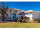 Front entry with arched entryway, teal door, and stone landscaping at 831 Via Tunis, Punta Gorda, FL 33950