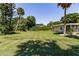 Large backyard with lush grass and palm trees at 2112 Mark Ave, Punta Gorda, FL 33950