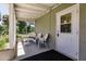 Screened porch with white wicker chairs and side table at 2112 Mark Ave, Punta Gorda, FL 33950