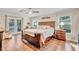 Spacious main bedroom featuring wood floors, a ceiling fan, a king bed, and access to the lanai at 98 Seasons Dr, Punta Gorda, FL 33983