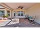 Covered brick patio with ceiling fan, seating, and ample natural light perfect for outdoor relaxation and entertaining at 98 Seasons Dr, Punta Gorda, FL 33983