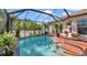 Beautiful pool with an attached screened-in lanai surrounded by lush greenery at 98 Seasons Dr, Punta Gorda, FL 33983