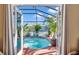 View of pool and landscaped patio area through open French doors at 98 Seasons Dr, Punta Gorda, FL 33983