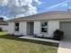 Charming single-story home with a well-maintained lawn and neutral-toned trim accents and an attached garage at 20399 Ladner Ave, Port Charlotte, FL 33954