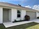 A well-maintained home featuring a neutral exterior, attached garage, a sidewalk leading to the front door, and trimmed landscaping at 20399 Ladner Ave, Port Charlotte, FL 33954