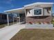 Mobile home exterior with covered carport, landscaping, and stone accents at 6603 Hauli Ct, North Port, FL 34287