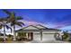 Single-story house with a two-car garage and palm trees at 25228 Nocturne Ln, Punta Gorda, FL 33983