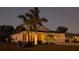 One-story home with a well-lit landscape at night at 25228 Nocturne Ln, Punta Gorda, FL 33983