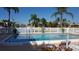 Community pool with surrounding patio furniture and canal view at 1345 Mediterranean Dr # A203, Punta Gorda, FL 33950