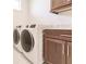 Laundry room with modern washer and dryer and wood cabinets at 425 Orinoco St, Punta Gorda, FL 33983