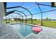 Screened-in pool with a flamingo float, backyard view at 425 Orinoco St, Punta Gorda, FL 33983