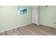 Bright bedroom featuring wood-look flooring and a window with natural light at 1190 Victoria Ave Nw, Port Charlotte, FL 33948