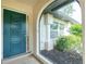 Close-up of the front door and entryway of the home with garden views at 1190 Victoria Ave Nw, Port Charlotte, FL 33948