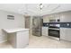 Updated kitchen with stainless steel appliances, island, and stylish blue backsplash at 1190 Victoria Ave Nw, Port Charlotte, FL 33948
