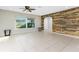 Bright living room with tile flooring, a rustic wood accent wall, and large window at 1190 Victoria Ave Nw, Port Charlotte, FL 33948
