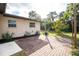 Back patio area showing the brick paving, landscaping and side of house with windows at 1190 Victoria Ave Nw, Port Charlotte, FL 33948