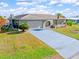 Single-story house with a light-grey driveway and lush green landscaping at 138 Peckham Sw St, Port Charlotte, FL 33952