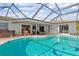 Enclosed kidney-shaped pool with hot tub and patio furniture at 138 Peckham Sw St, Port Charlotte, FL 33952
