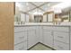 Double vanity bathroom with white cabinets and a corner sink at 18491 Hottelet Cir, Port Charlotte, FL 33948
