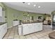 Open kitchen with large island, white cabinets, and stainless steel appliances at 18491 Hottelet Cir, Port Charlotte, FL 33948