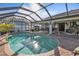 Enjoy this relaxing kidney-shaped pool and screened patio area at 18491 Hottelet Cir, Port Charlotte, FL 33948