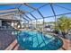 Enclosed pool with brick deck and canal views at 18491 Hottelet Cir, Port Charlotte, FL 33948