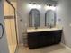 Double vanity bathroom with large mirrors and a walk-in shower at 2201 Grand Flora Trl, Bradenton, FL 34208