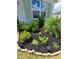 Landscaped front yard with various plants, mulch, and solar lighting at 2201 Grand Flora Trl, Bradenton, FL 34208