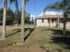 Charming single-story home with a well-maintained lawn, palm trees, and a covered porch at 2410 Lanier Rd, Punta Gorda, FL 33982