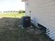 Side view of a house with HVAC system, featuring a well-maintained lawn and a backyard at 2410 Lanier Rd, Punta Gorda, FL 33982