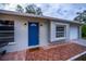 Updated house exterior with a blue door and terracotta tile walkway at 4485 Herder St, Port Charlotte, FL 33948