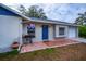 House exterior featuring a blue door, tile patio, and attached garage at 4485 Herder St, Port Charlotte, FL 33948