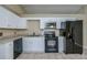 Modern kitchen with white cabinets, black appliances, and granite countertops at 4485 Herder St, Port Charlotte, FL 33948
