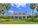 Community clubhouse with a classic design, welcoming porch, and lush landscaping at 1796 Scarlett Ave, North Port, FL 34289