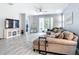 Bright living room with sectional sofa, large TV, and sliding glass doors leading to the patio at 1796 Scarlett Ave, North Port, FL 34289