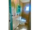 Bright bathroom features colorful shelves, a round mirror, and a tiled shower at 30431 Holly Rd, Punta Gorda, FL 33982