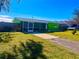 Charming single-story home with bright green exterior paint, screened in porch and a spacious driveway at 30431 Holly Rd, Punta Gorda, FL 33982