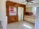 Vintage kitchen features wood walls and cream-colored cabinets with ceiling fan for added circulation at 30431 Holly Rd, Punta Gorda, FL 33982