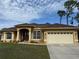 Tan house with a brown tile roof, two-car garage, and well-maintained lawn at 3100 Sheboygan Ave, North Port, FL 34286